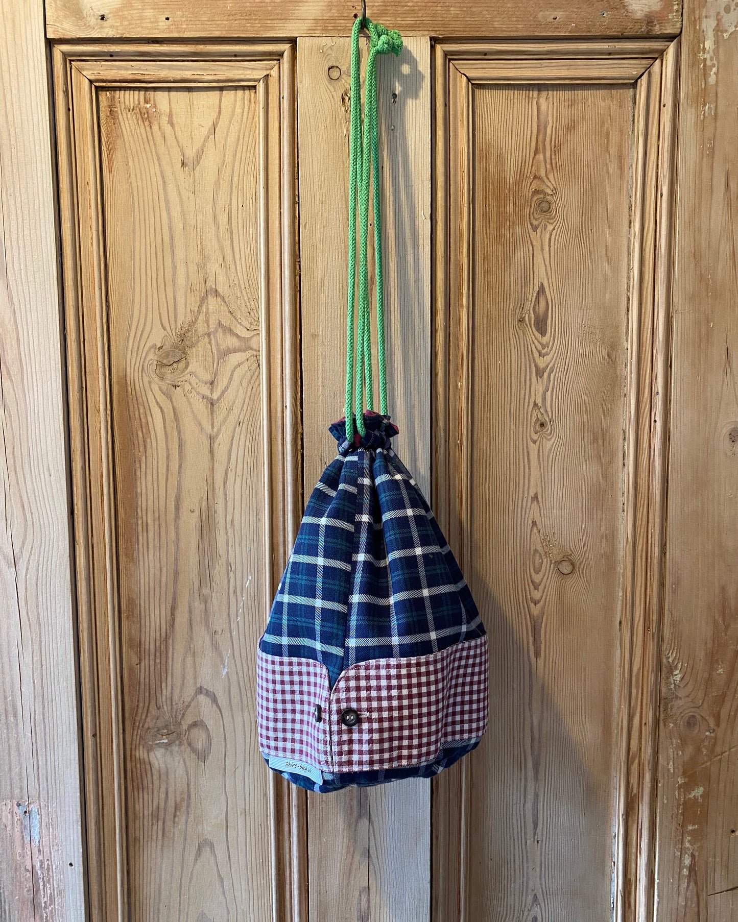 Duffle - Dark green & navy tartan with red & white check cuffs